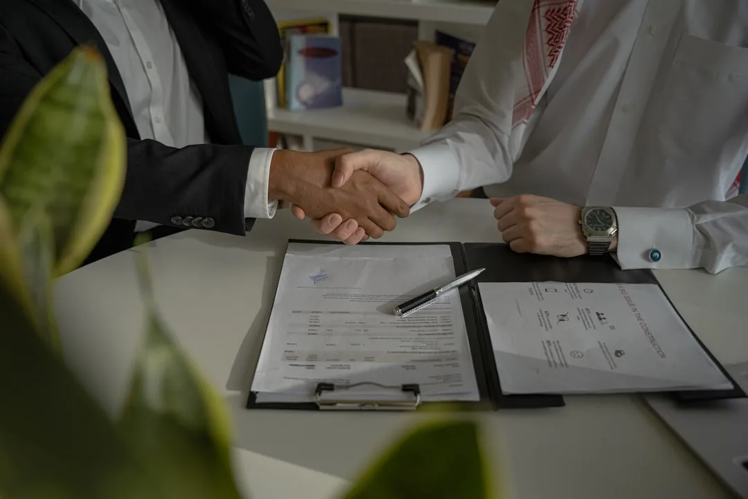 Handshake over a desk with legal documents - Immigration attorney Columbus Ohio